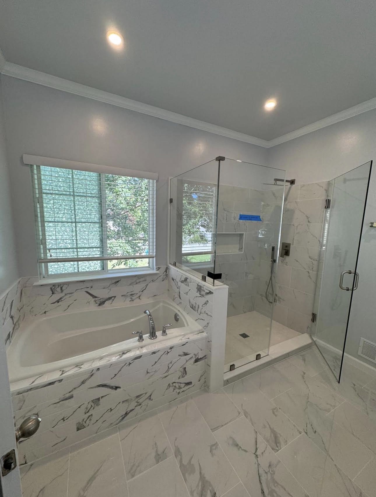 H & K bathroom project with a glass shower and marble-look tile