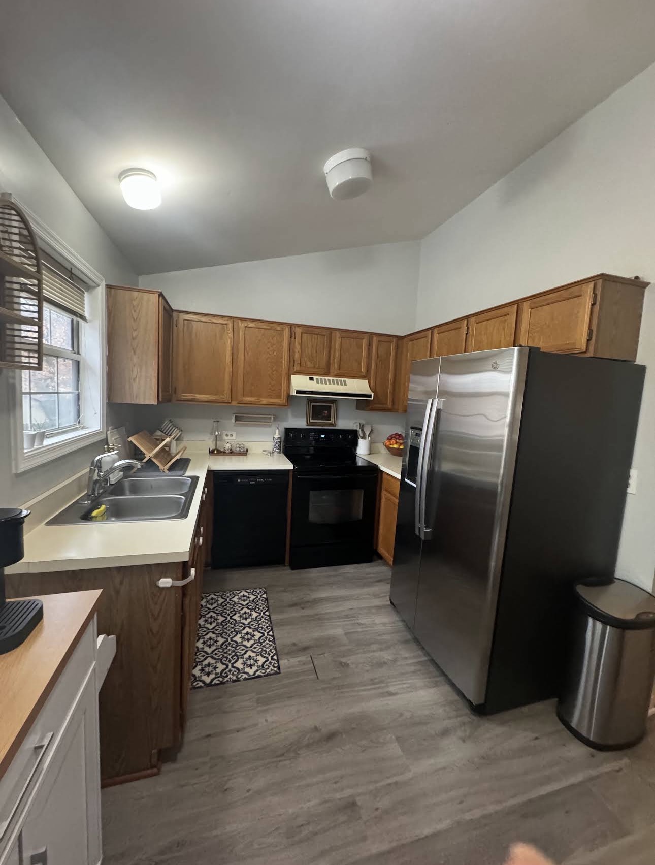 Clean kitchen with oak cabinets and wood-look flooring