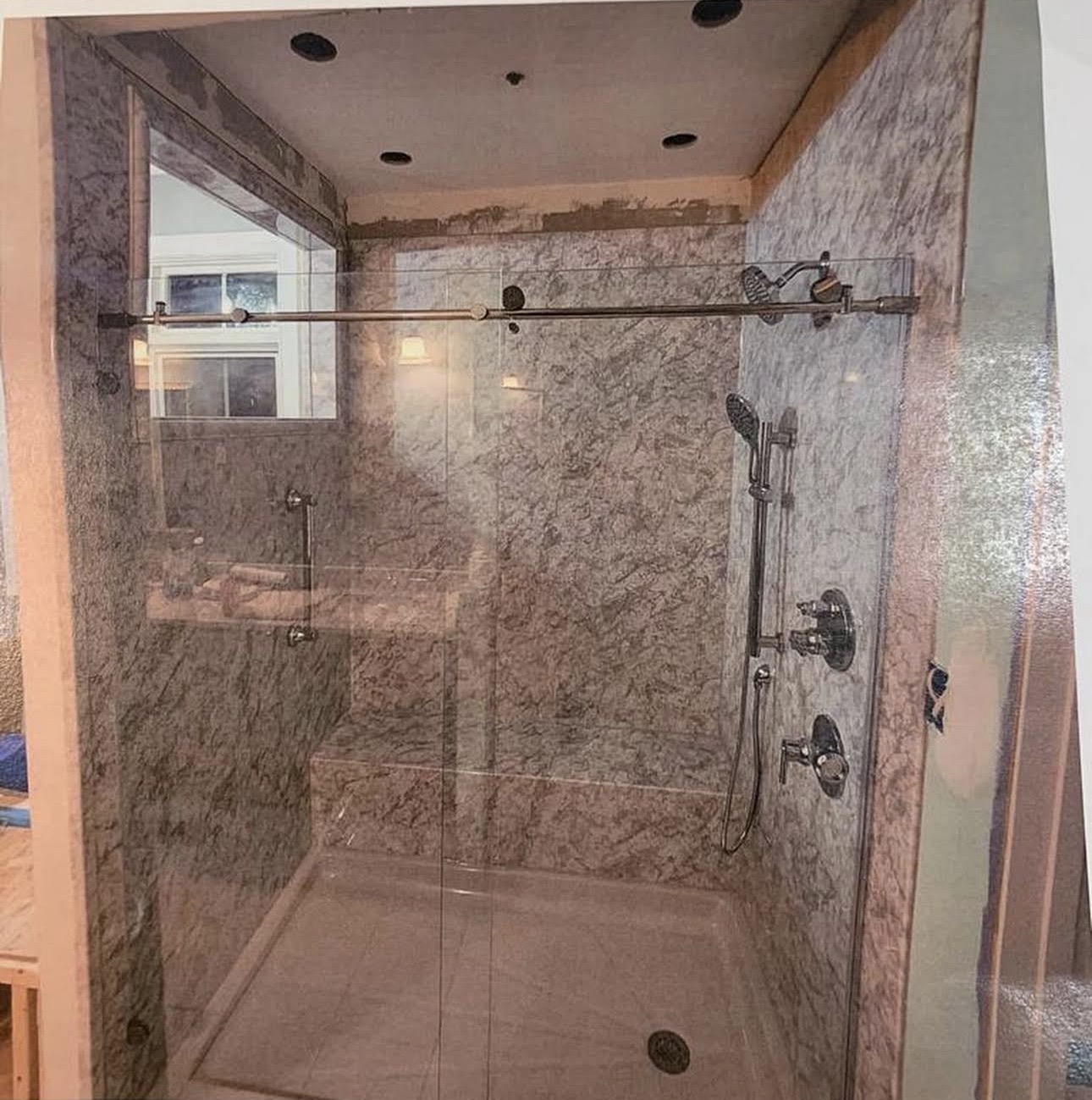 Glass shower enclosure with stone-look walls